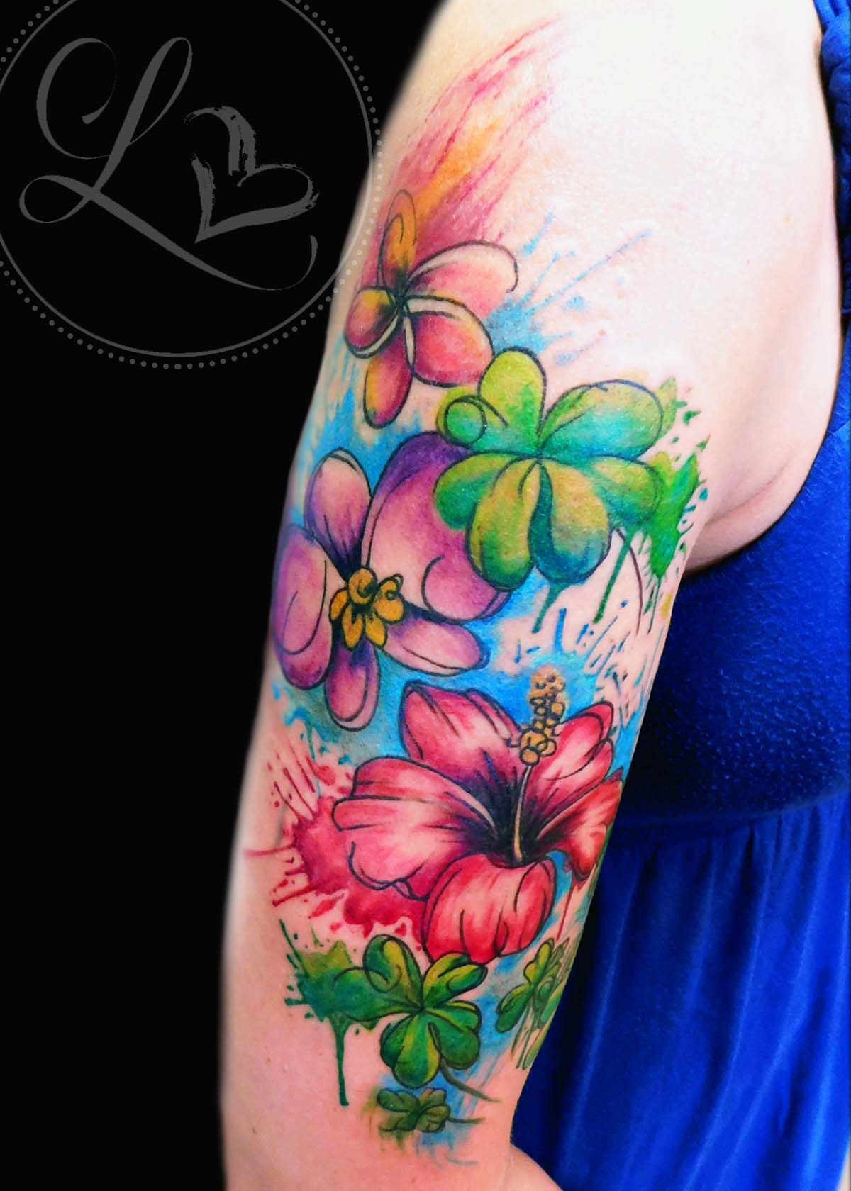Watercolor floral half-sleeve tattoo composed of plumeria, hibiscus, orchid, and four-leaf clovers
