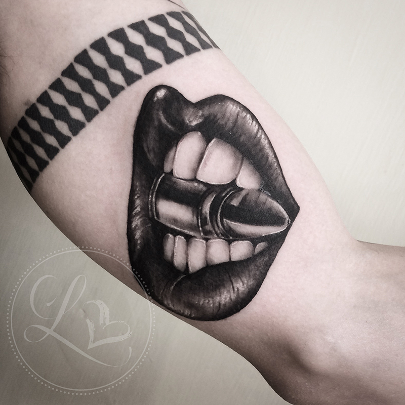 Realistic black and grey tattoo of liips and teeth biting down on a bullet