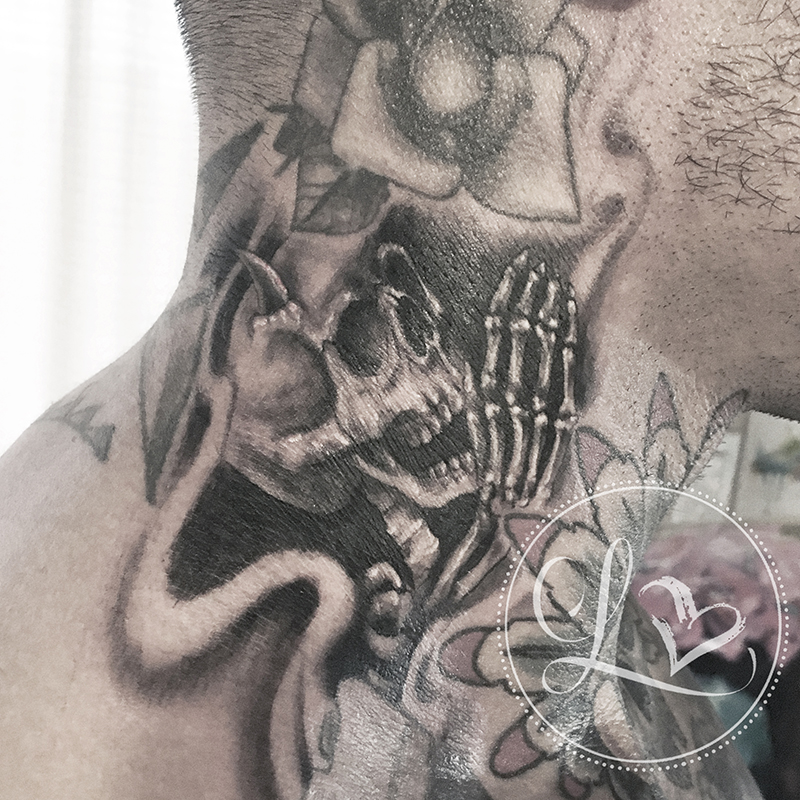 Black and grey realistic tattoo on a man's neck of a skeleton with devil horns whispering into an ear