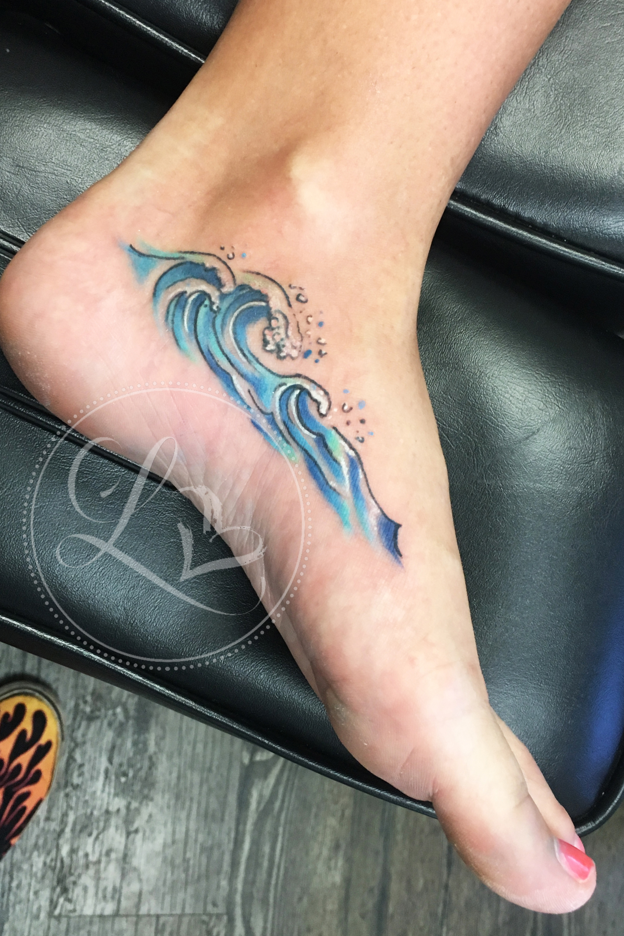 Watercolor wave foot tattoo