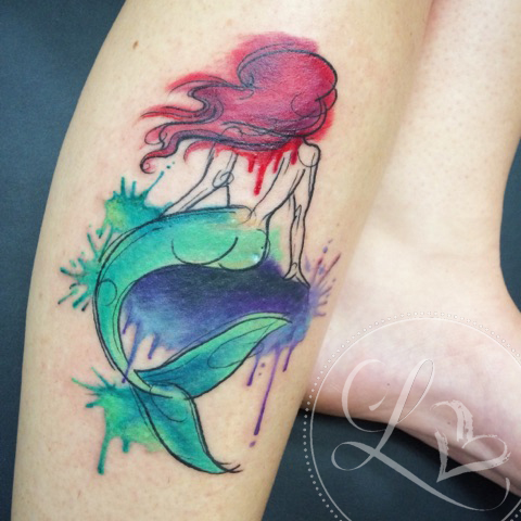 Watercolor tattoo of Disney's The Little Mermaid sitting on a rock from behind
