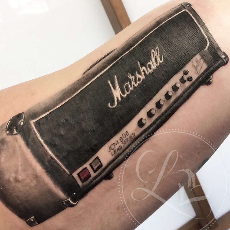 Realistic black and grey tattoo on an inner arm of a Marshall guitar amplifier