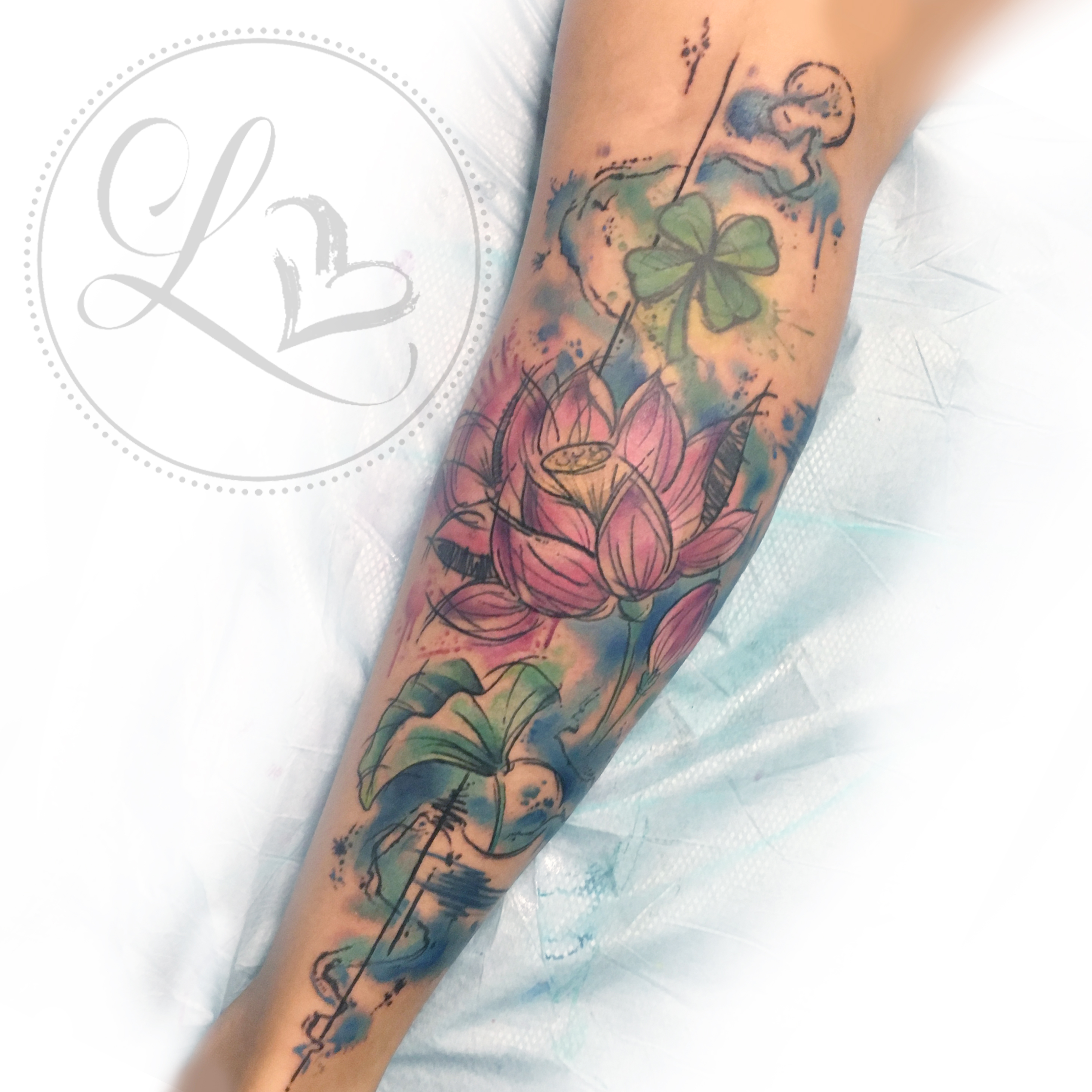 Watercolor style leg half-sleeve tattoo of lotus flowere and lily pads