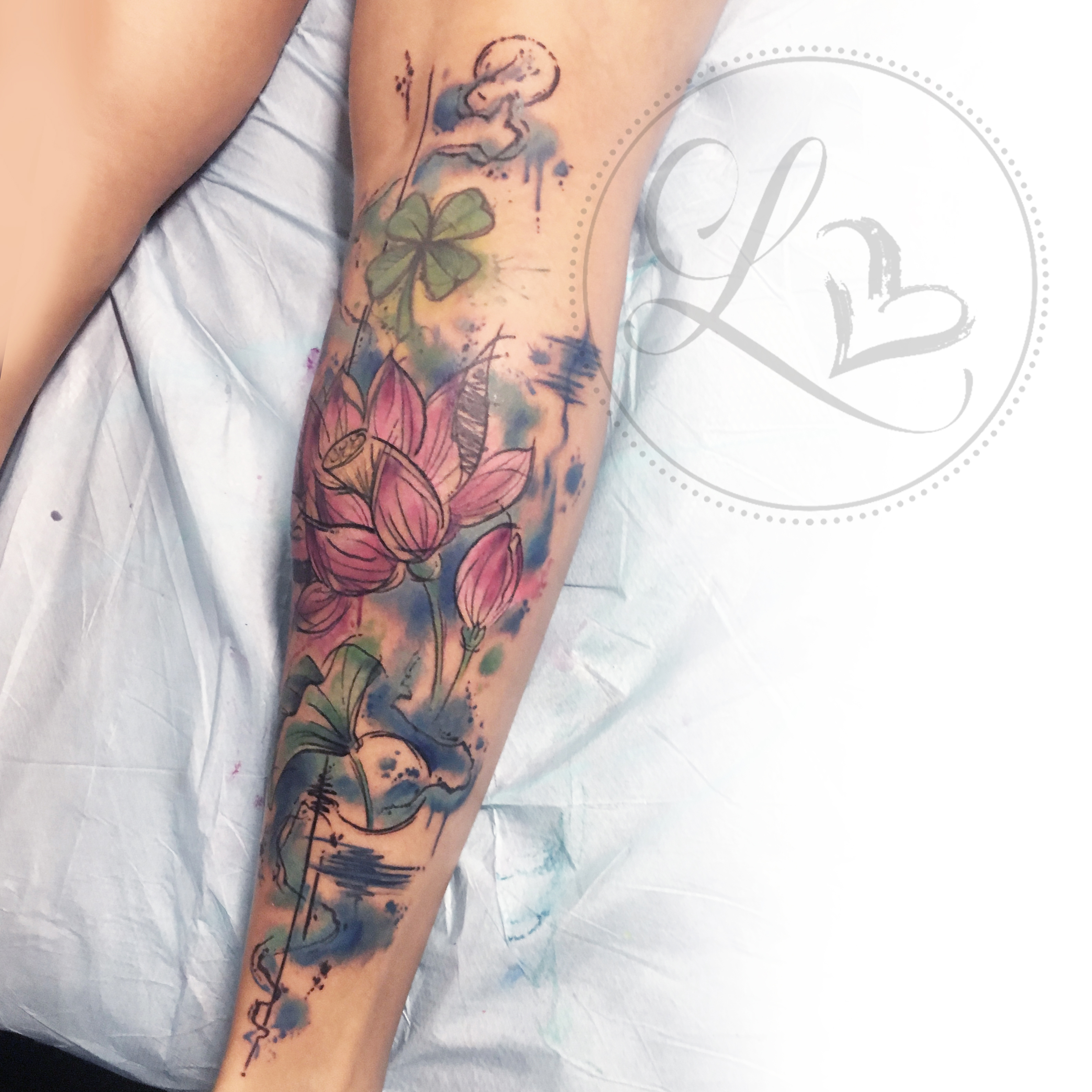 Watercolor style leg half-sleeve tattoo of lotus flowere and lily pads