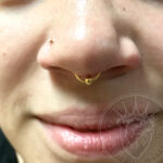 Septum piercing with a 16g gold anodized titanium captive bead ring