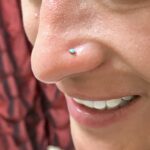 Nostril nose piercing done with a turquoise-dyed howlite cabochon nostril screw