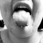 "Snake eyes" piercing - transverse / horizontal tongue piercing with a 14g curved barbell - done by Lhena - Queen of Hearts, Wailuku, Maui. Vertical labret (partially shown) also by Lhena.